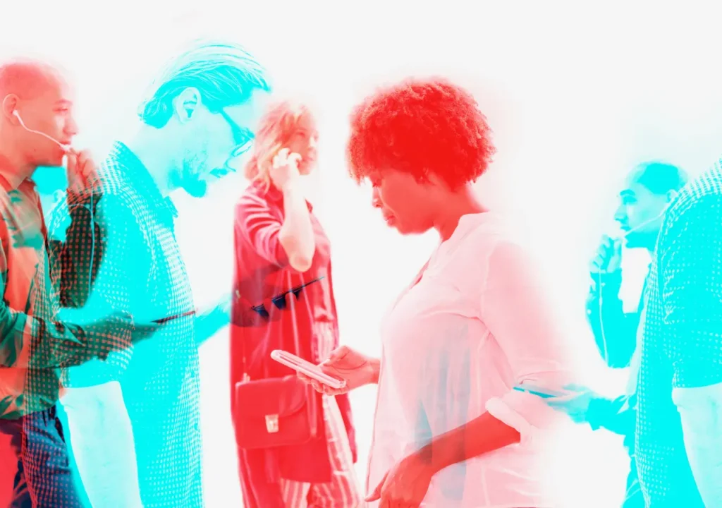 Personas diversas utilizando dispositivos móviles con efecto digital en doble color, simbolizando la relación entre inteligencia artificial y diversidad en el trabajo
