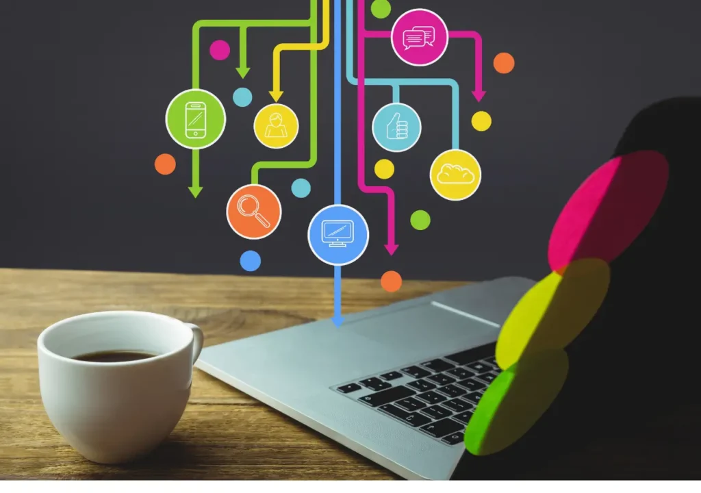 Computadora portátil sobre una mesa con una taza de café, mostrando diversos íconos digitales que simbolizan la presencia online, las redes sociales y la marca personal.
